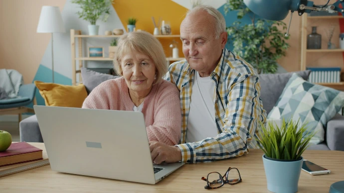 Elderly couple looking at a laptop together